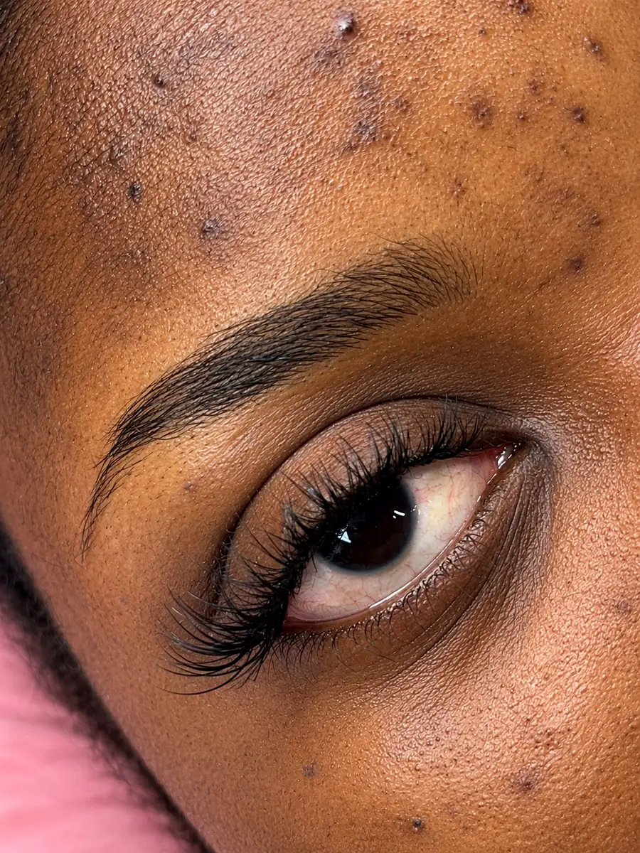 Close-up of an eye with a wispy lash set and shaped, defined brows